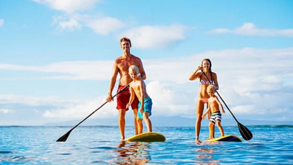 Familia al completo practicando paddlesurf con una tabla familiar de construcción inflable.